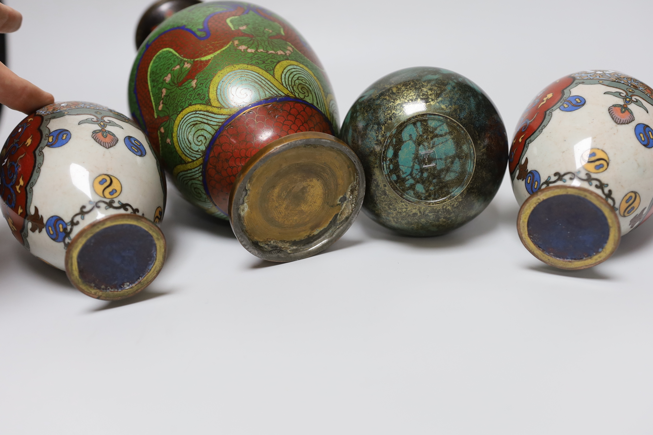 A pair of Japanese cloisonné enamel vases, a Chinese cloisonné enamel vase and a signed mottled bronze bottle vase, tallest 26cm